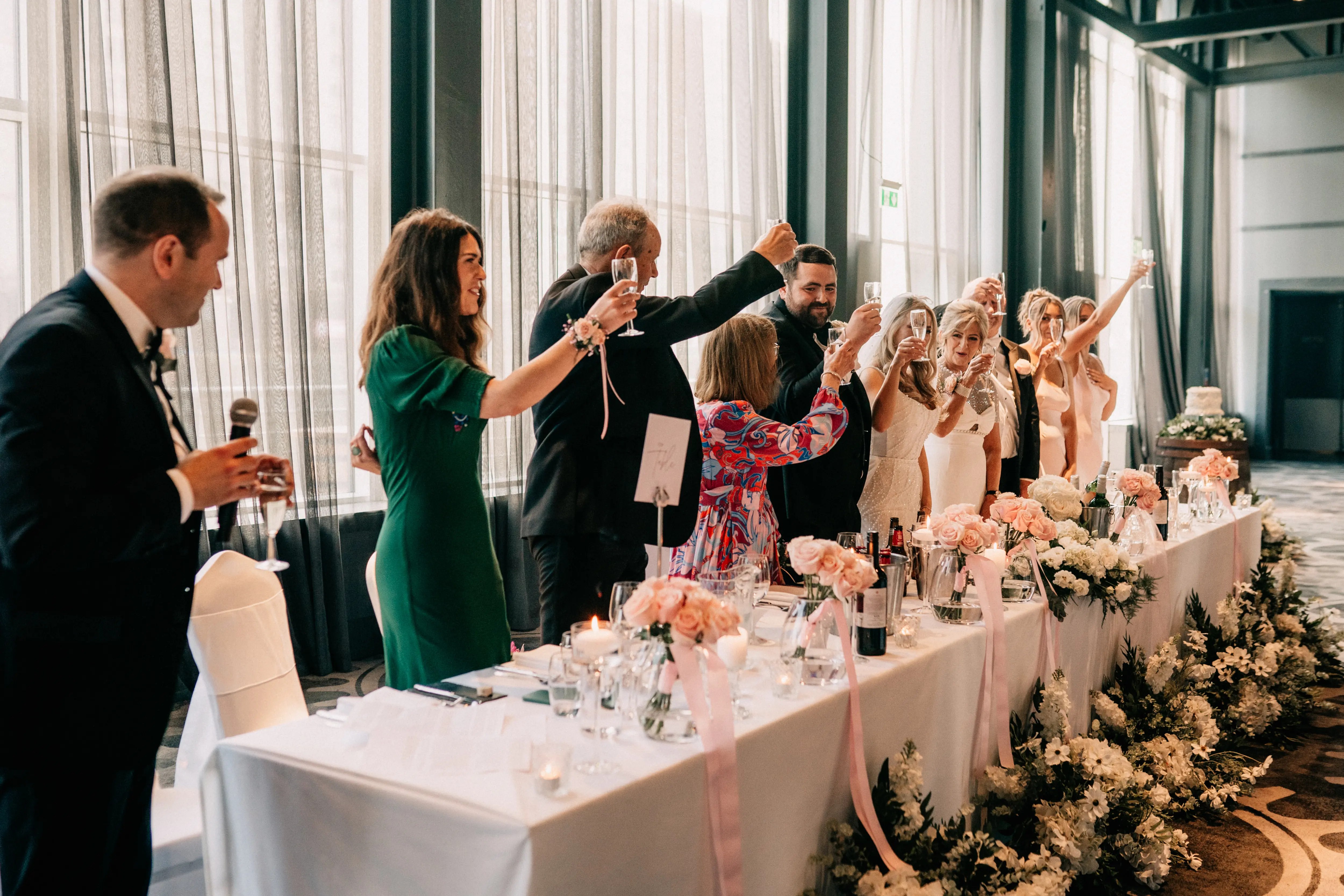 Using aisle meadow flowers in front of a long top table at a wedding reception